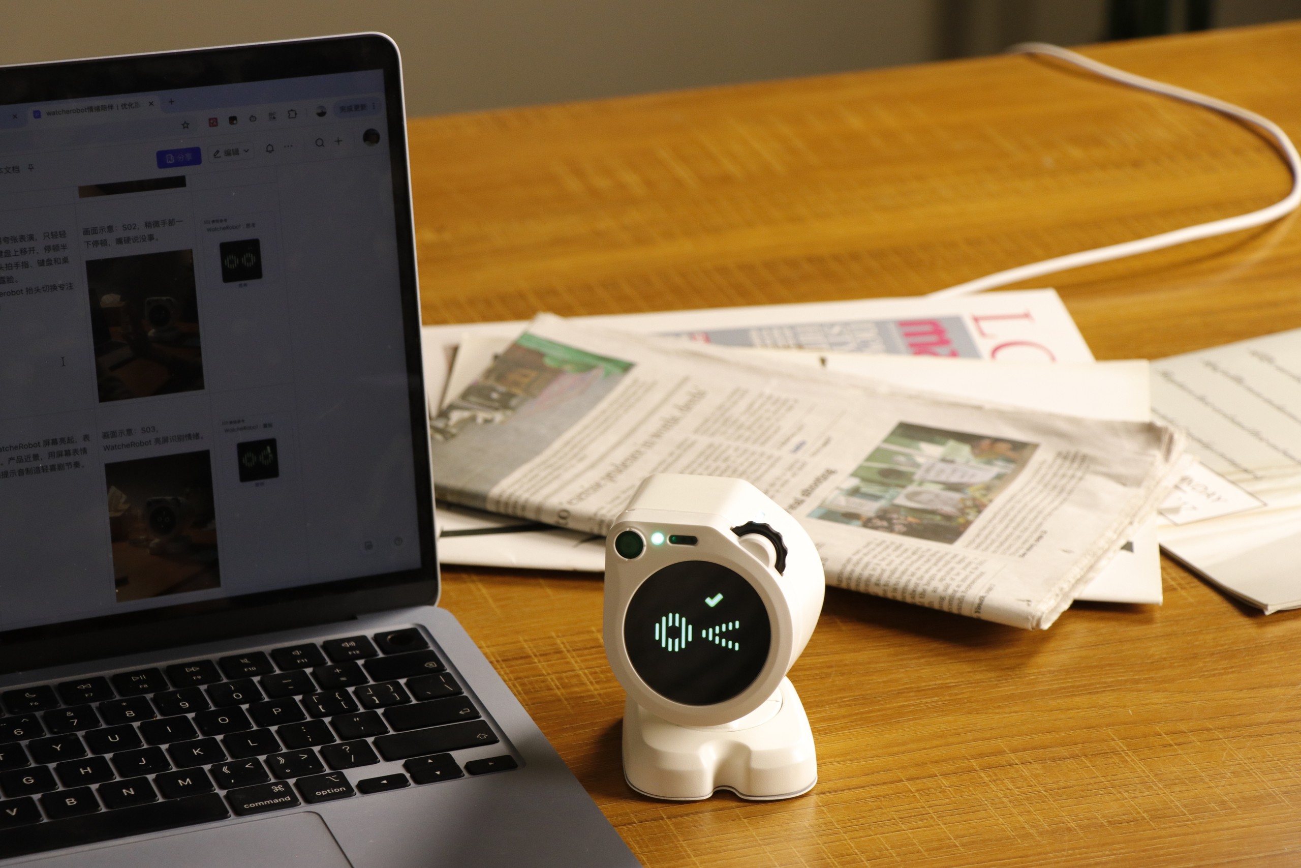 WatcheRobot 在笔记本与文档旁展示